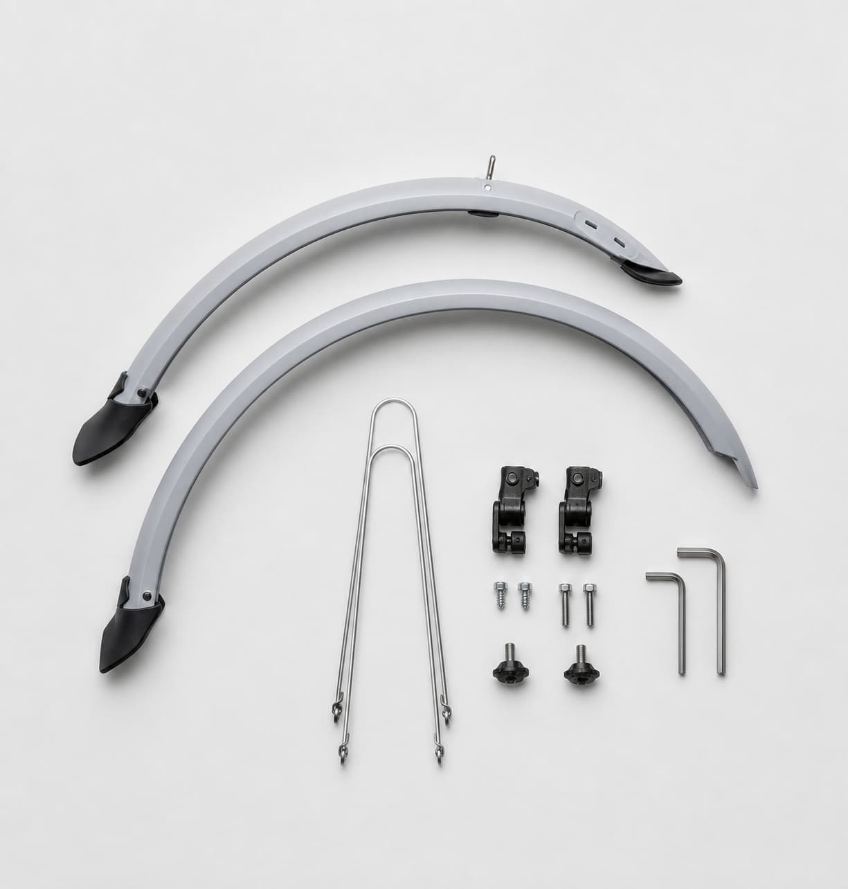 Garde-boue de vélo en plastique flexible pour roues de 24 à 28 pouces, avec attaches réglables, placé à côté de clés Allen sur un fond gris clair, photographié du dessus avec un éclairage doux.